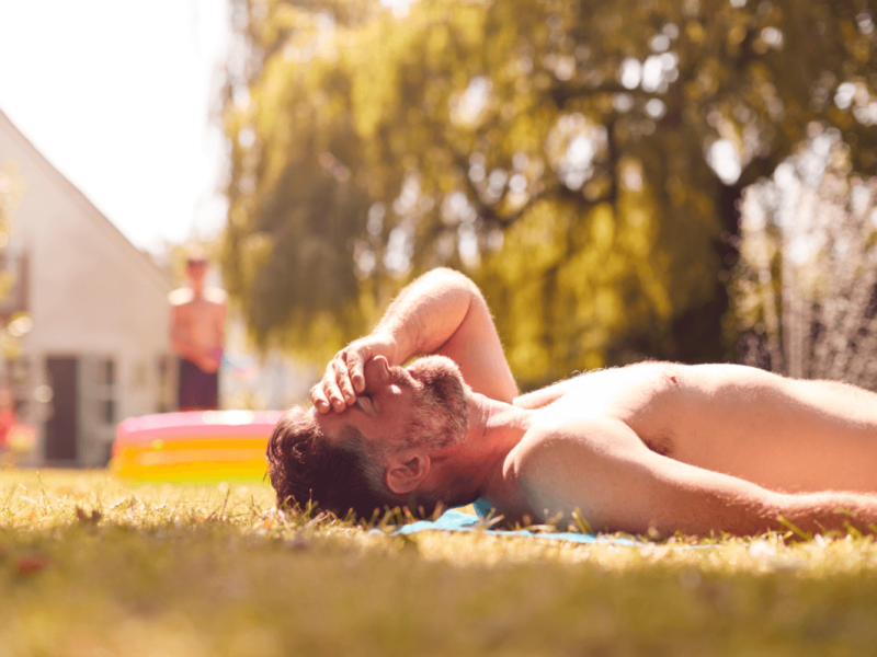 Damm sonnen. Symbolbild: Mann liegt oberkörperfrei auf einer Wiese in der Sonne. English: Perineum Sunning. Symbolic image: Man lying bare-chested in the sun on a meadow.