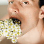 Deep Throat Tipps für Empfänger. Symbolbild: Ein Mann steckt sich einen Strauß Blumen tief in den Hals und schaut lüstern. Englisch: Deep throat tips for recipients. Symbolic image: A man sticks a bunch of flowers deep down his throat and looks lustfully.