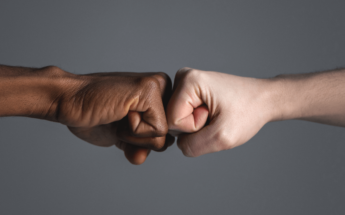 Fisting-Community Infos. Symbolbild: eine hell- und eine dunkelhäutige Faust. Englisch: Fisting community info. Symbolic image: a light-skinned and a dark-skinned fist.