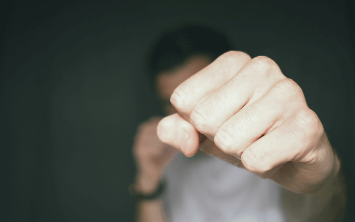 Schwule Männer Beratung. Symbolbild: Eine Männer-Faust, die zum Kampf erhoben ist. Englisch: Gay men's counseling. Symbol: a man's fist raised in a fight.