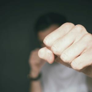 Schwule Männer Beratung. Symbolbild: Eine Männer-Faust, die zum Kampf erhoben ist. Englisch: Gay men's counseling. Symbol: a man's fist raised in a fight.