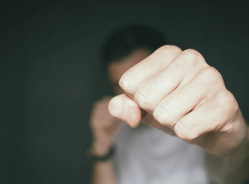 Schwule Männer Beratung. Symbolbild: Eine Männer-Faust, die zum Kampf erhoben ist. Englisch: Gay men's counseling. Symbol: a man's fist raised in a fight.