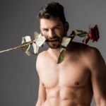 Analprolaps und Rosebud. Symbolbild: Mann mit nacktem Oberkörper trägt eine Rose im Mund. Englisch: Anal prolapse and rosebud. Symbolic image: Man with a naked upper body wearing a rose in his mouth.