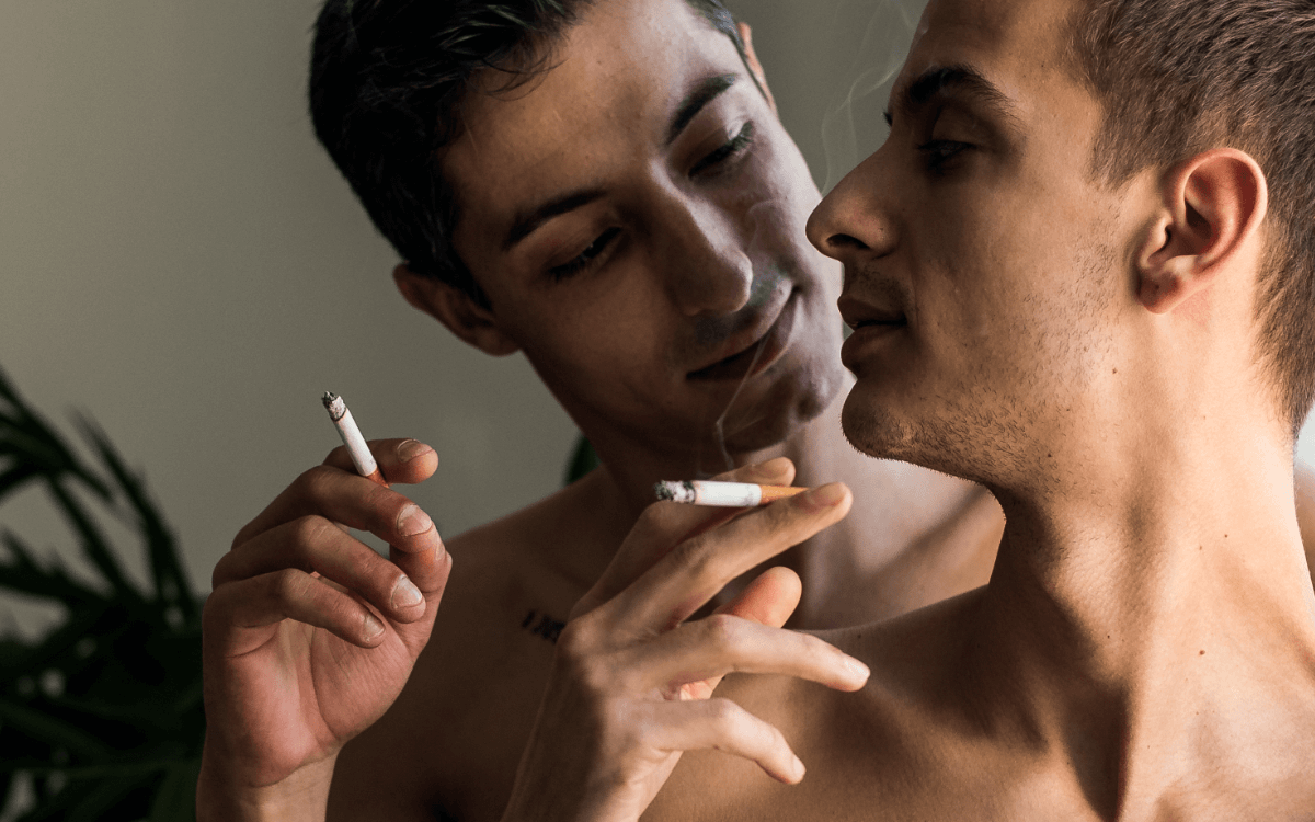 Smoking Fetisch. Die erotische Anziehungskraft des rauchens. Symbolbild: Zwei rauchende Männer mit nacktem Oberkörper. Englisch: Smoking fetish. The erotic attraction of smoking. Symbolic image: Two men smoking with naked upper bodies.