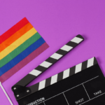 Queere Filme. Symbolbild: Filmklappe und Regenbogenfahne. Englisch: Queer movies Symbolic image: movie flap and rainbow flag.