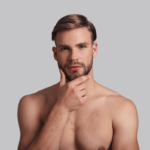 Analverkehr Fragen. Symbolbild: Mann mit nacktem Oberkörper hält die Hand ans Kinn und überlegt. Englisch: Anal intercourse questions. Symbol picture: man with naked upper body holds his hand to his chin and thinks.