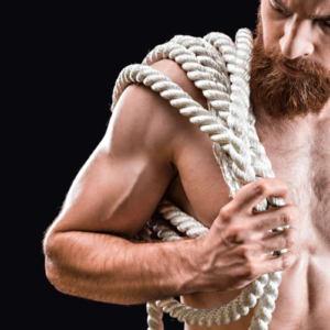 Rigger BDSM oder Rope Top. Symbolbild: Ein Mann mit freiem Oberkörper trägt ein dickes Seil. Englisch: Rigger or rope top. Symbolic image: a shirtless man carries a thick rope.