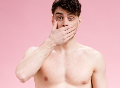 Angstspiele: Ein Mann mit freiem Oberkörper hält sich vor Entsetzen die Hand vor den Mund. Englisch: Fear play: A man with his upper body exposed covers his mouth in horror.
