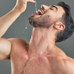 Gagging Symbolic image: A man with a bare upper body allows water to drip deep into his throat.