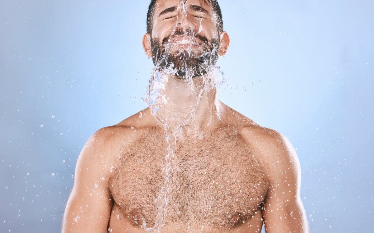 Darmspülung Symbolbil: Mann mit nacktem Oberkörper bekommt Wasser über das Gesicht geschüttet. Englisch: Bowel cleansing Symbolic image: Man with bare upper body having water poured over his face.