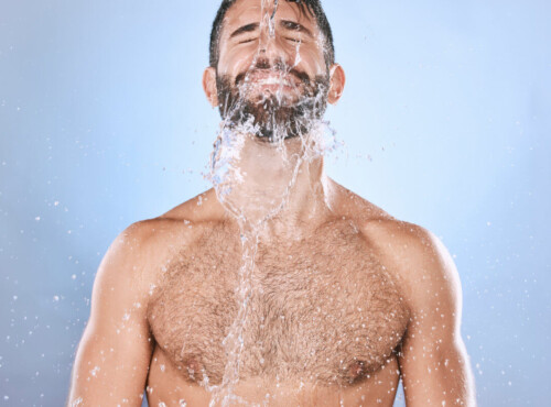 Darmspülung Symbolbil: Mann mit nacktem Oberkörper bekommt Wasser über das Gesicht geschüttet. Englisch: Bowel cleansing Symbolic image: Man with bare upper body having water poured over his face.