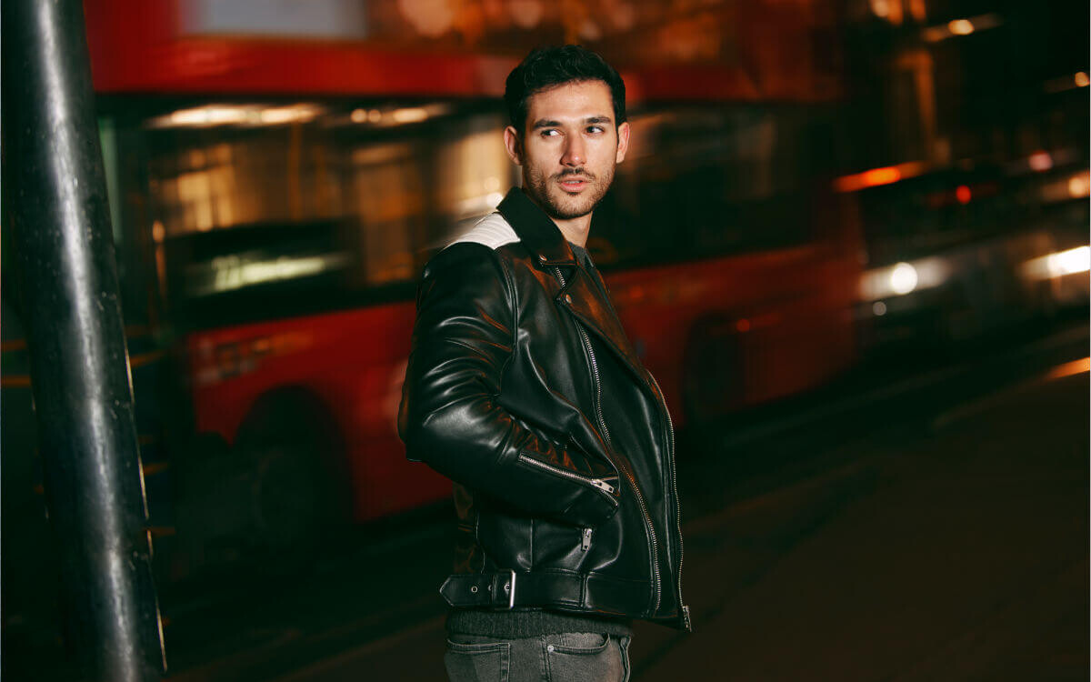 BDSM Benefits Symbolbild: Ein Mann schaut zurück richtung Kamera. Hinterhin fährt ein Bus vorbei. Englisch: BDSM benefits Symbolic image: A man looks back toward the camera. A bus drives past behind him.