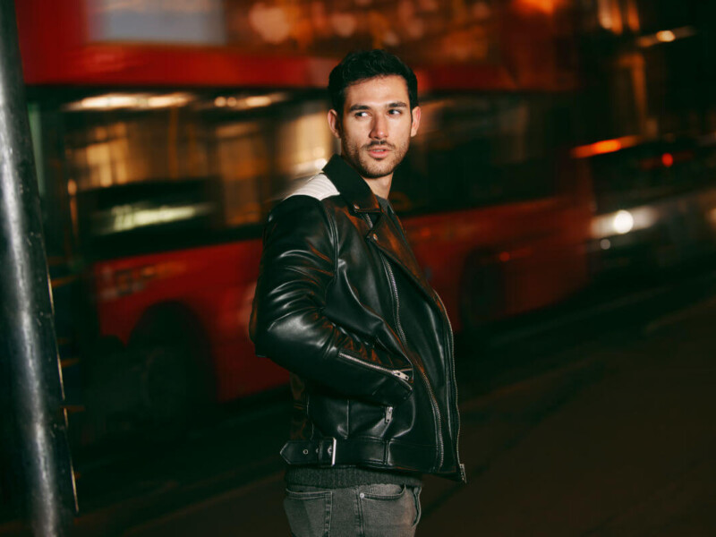 BDSM Benefits Symbolbild: Ein Mann schaut zurück richtung Kamera. Hinterhin fährt ein Bus vorbei. Englisch: BDSM benefits Symbolic image: A man looks back toward the camera. A bus drives past behind him.