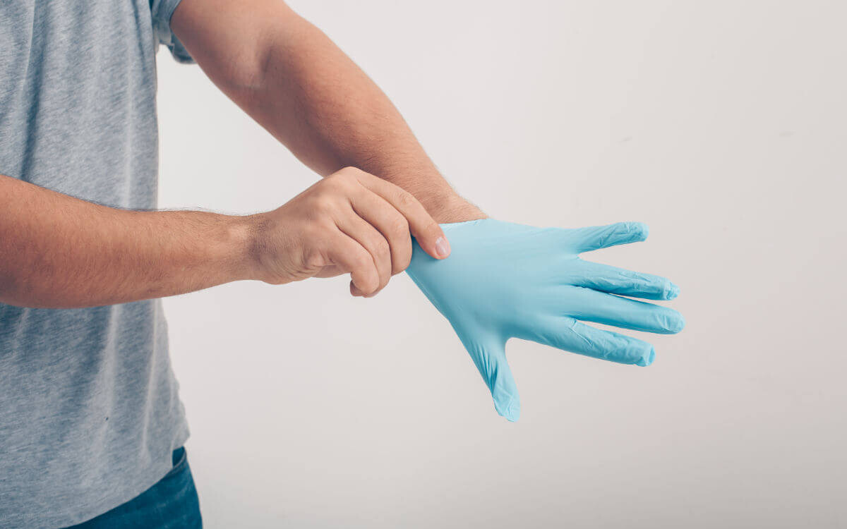 Fisting Verletzungen Symbolbild: Ein Mann zieht sich einen Handschuh über. Englisch: Fisting injuries Symbolic image: A man pulls on a glove.